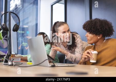 Diverse colleagues discussing over computer in office Stock Photo