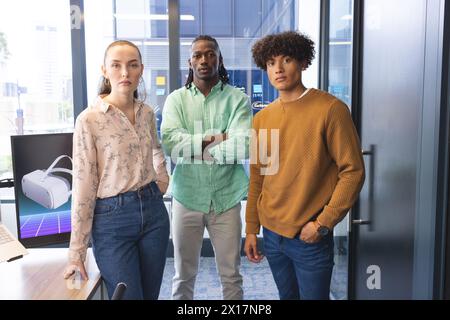 Diverse team standing in office, looking serious Stock Photo