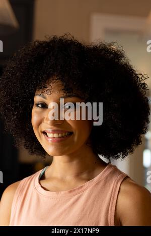 Biracial young woman smiling, wearing casual clothes at home Stock Photo