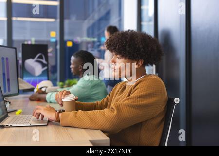 Diverse colleagues focusing on work in modern office using laptops Stock Photo