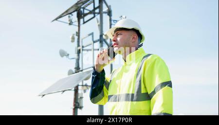Man, phone call and engineer in conversation for solar panel maintenance or inspection on rooftop. Male person, contractor or technician talking on Stock Photo