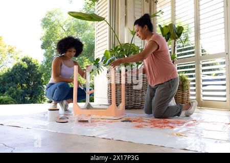 Biracial Mother And Adult Daughter Are Painting Together At Home. Both 