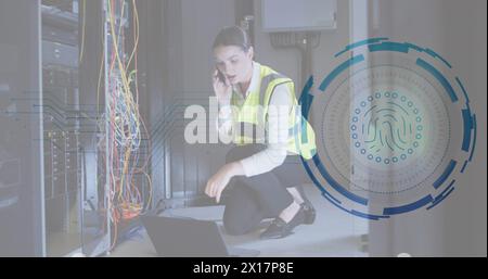 Image of fingerprint scanner over caucasian female engineer talking on smartphone at server room Stock Photo