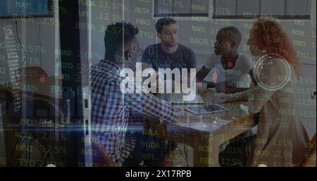 A group of young businesspeople are sitting in a meeting room discussing financial data on a laptop Stock Photo