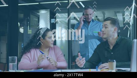 Image of arrows with data processing over diverse business people working in office Stock Photo