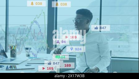 Image of notification bars and graphs over thoughtful african american man sitting in office Stock Photo