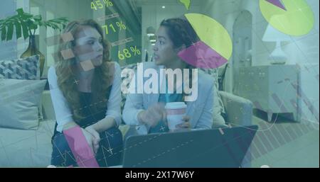 Image of statistical data processing against two diverse women discussing over laptop at office Stock Photo