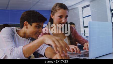 Image of multiracial students studying using laptop in classroom over trading board and graph Stock Photo