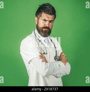Healthcare, treatment and medical staff concept. Portrait of serious male doctor in workwear with stethoscope on neck. Handsome bearded intern Stock Photo