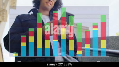 Image of colourful graph over smiling biracial man using smartphone in street Stock Photo