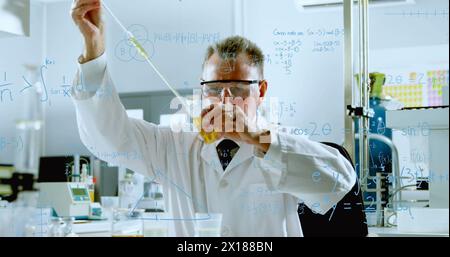 Image of mathematical equations over caucasian male scientist in lab Stock Photo