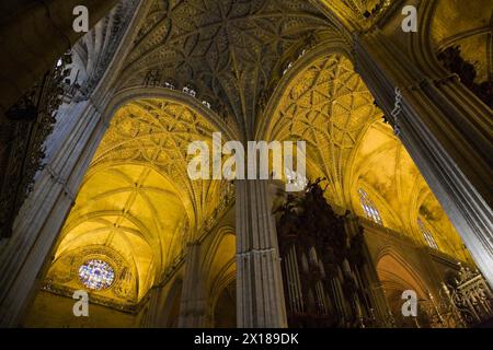 Architectural details on ceiling and stained glass rose window in Interior of The Cathedral of Saint Mary of the See or Seville Cathedral, Seville Stock Photo