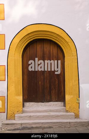 Old wooden entrance door with doorstep and yellow contour on facade of Stadtsall hotel building in medieval town of Nordlingen, Bavaria, Germany Stock Photo