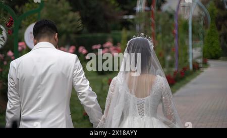 The bride and groom are walking in the park on their wedding day Stock Photo