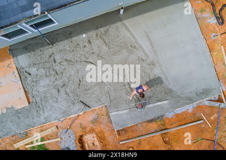 Concrete is leveled by construction worker using special tool Stock Photo