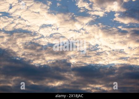 Blue sky background with small golden clouds. Horizontal. Texture Stock Photo
