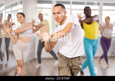 Young Asian male instructor leading modern dance class Stock Photo
