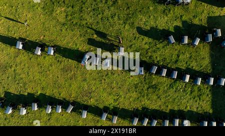 From the sky, the orderly arrangement of Amish buggies casts long shadows on the grass, evoking a sense of community and tradition at day's end. during an Amish Wedding Stock Photo