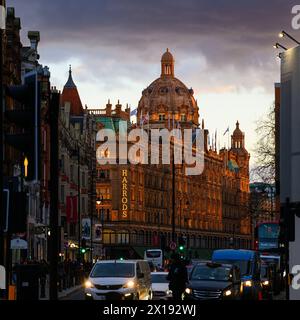 London, UK - March 22, 2024; View west along Brompton Road to Harrods departments store with lights Stock Photo