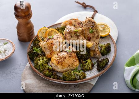 Chicken drumsticks and thighs with broccoli roasted on a serving plate for dinner or lunch Stock Photo