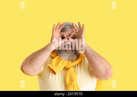 Mature bearded man showing OK on yellow background Stock Photo
