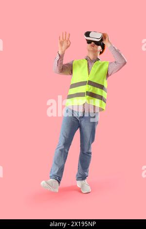 Male worker using VR glasses on pink background Stock Photo