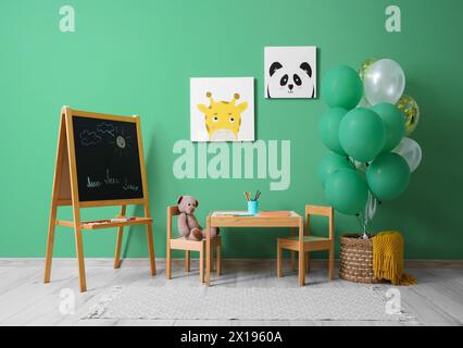 Interior of children's room with bunch of balloons, chalkboard and paintings Stock Photo