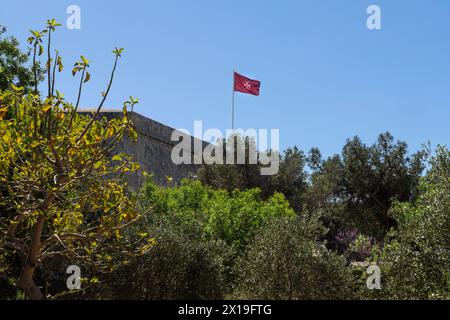 Valletta, Malta, April 03, 2024.  the flag with the Maltese cross flying on the ramparts in the city center Stock Photo