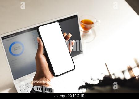 African American young female holding smartphone, showing screen at home with copy space Stock Photo