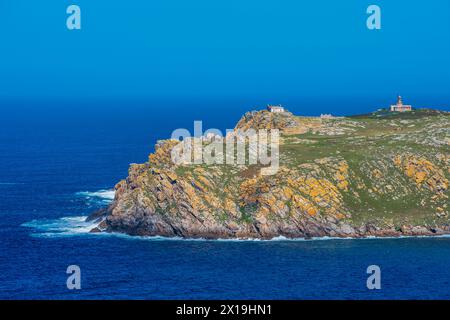 Rocky Coastal Landscape With Lighthouse Overlooking the Blue Sea at Dusk, View of Sisarga Grande in Malpica, Galicia, Spain Stock Photo