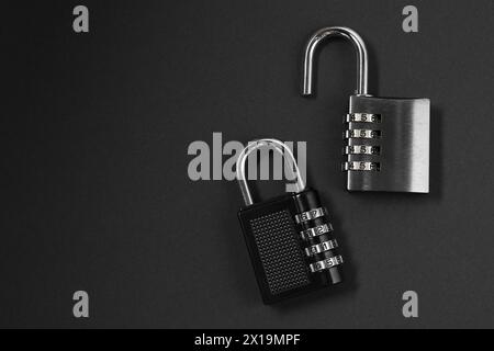 Steel combination padlocks on black background, top view. Space for text Stock Photo