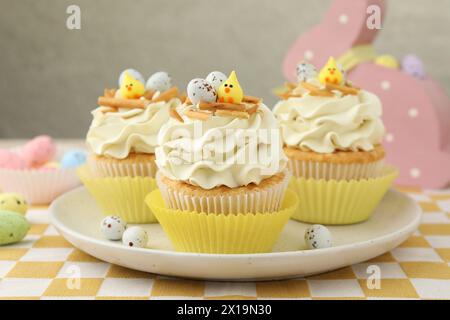 Tasty Easter cupcakes with vanilla cream on table, closeup Stock Photo