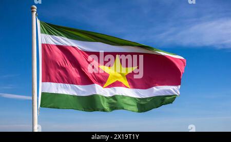 Die Fahne von Suriname, flattert im Wind, isoliert, gegen den blauen Himmel Stock Photo