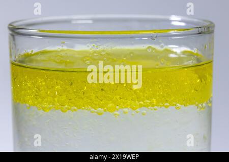 Close up of a layer of oil droplets floating to the top of water in a glass Stock Photo