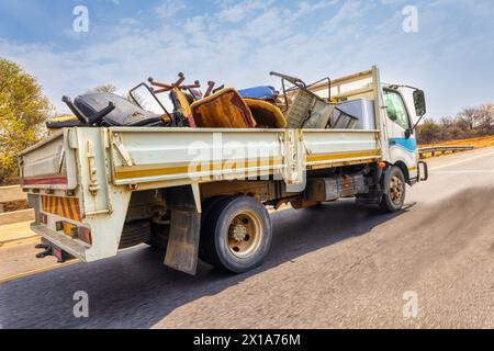 large truck on the city street, carry used broken furniture for recycling Stock Photo