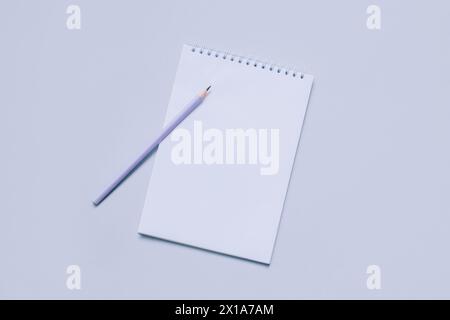 Notebook with blank page and pencil on light purple background. Flat lay. Place for text. Stock Photo