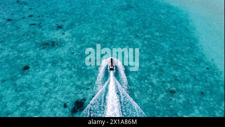 Jet Ski in the blue ocean of the Maldives, Indian Ocean leaving a wake behind it. Stock Photo