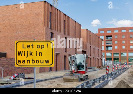 Sign with the Dutch text for 'Attention - Residential area under construction' in front of new family homes in Lent Nijmegen,  The Netherlands Stock Photo