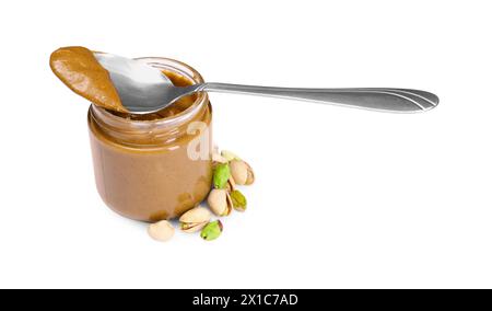 Tasty nut paste in jar, spoon and pistachios isolated on white Stock Photo