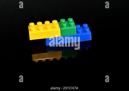 On a black background, a design assembled from different parts of a children's designer and its reflection. Stock Photo