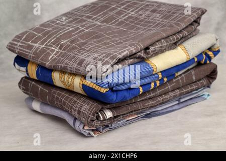 Close-up of a stack of bed linen, sheets, pillowcases on a light background. Stock Photo