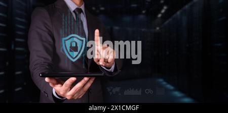 cybersecurity concept. man with tablet protects his digital information. shield icon with padlock and binary code. Stock Photo