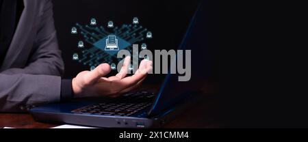 concept data in the cloud. executive in front of laptop holds hologram of data on online servers. black background Stock Photo