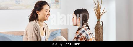 A mother and daughter having a heartfelt discussion in a warm and inviting bedroom. Stock Photo