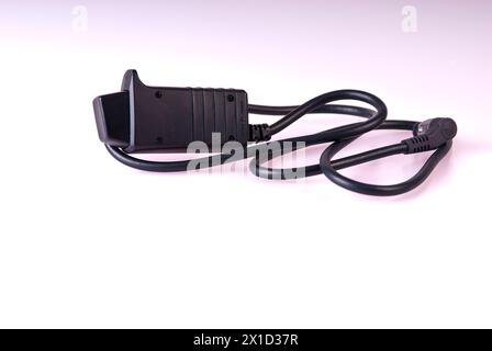 Close up of a remote shutter release cord for a professional digital camera isolated against a white background Stock Photo