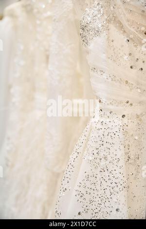 A serene moment in a bridal store with a pristine wedding dress hanging on a rack, waiting for a young bride Stock Photo