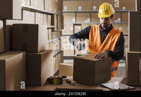 Warehouse clerk scanning labels on packages, delivery and logistics concept Stock Photo
