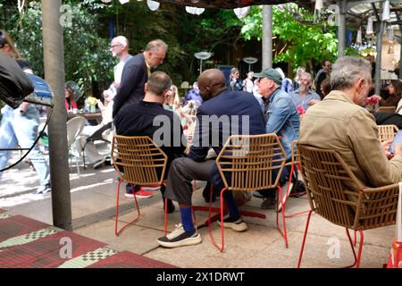 a yard with a bar full of people at the Rossana Orlandi Gallery, one of the top locations of Milan's Design Week Stock Photo