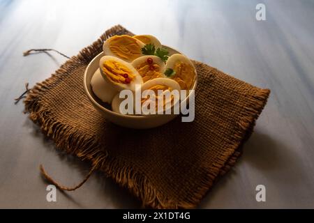 Sliced boiled eggs in a bowl with parsley leaves. Stock Photo
