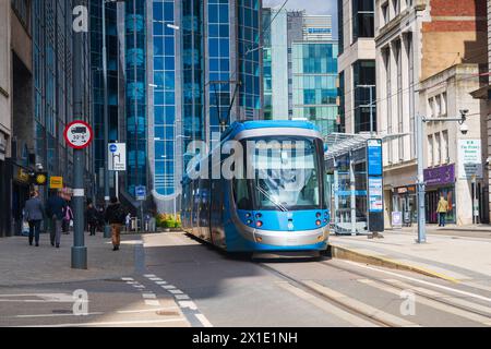 Birmingham, UK 16th April 2024:  Birmingham tram running through Bull Street in the City Centre with high rise buildings Stock Photo